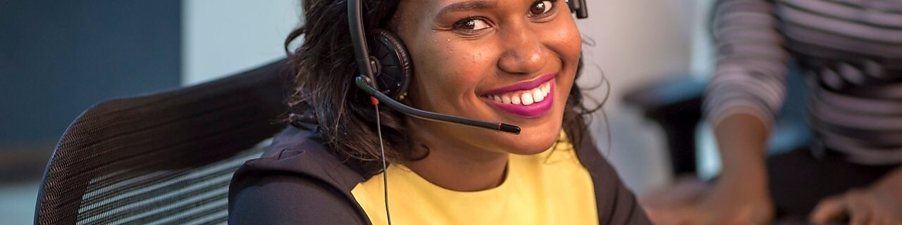 Collaboratrice souriante au téléphone avec un client