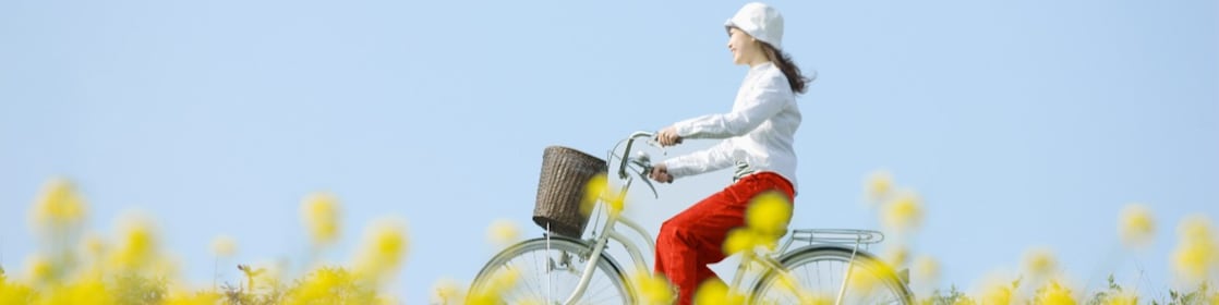 Une jeune femme fait une balade à vélo dans un champ en fleurs en été