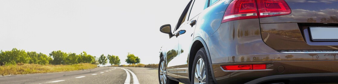 Voiture rouge circulant sur une route au bord d'une rivière