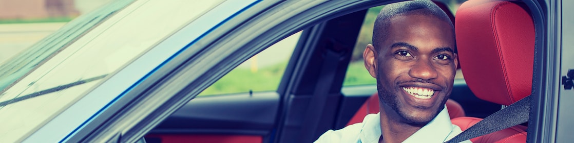 man putting on seat belt in a car