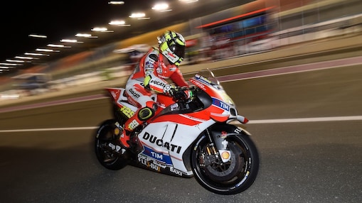 Pilote Ducati roulant vite sur une moto, sur un circuit, de nuit
