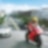 Moto rouge et conducteur sur une route avec des voitures et des bâtiments dans l’arrière-plan.