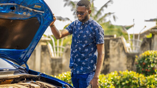 Un automobiliste vérifiant l'état de son moteur sur la route